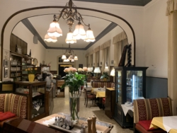 „Es war die Zeit, da er sich das nahegelegne Café Zartl als Zufluchtsstätte wählte. Dort saß er oft bis zur Sperrstunde in seiner Sofanische, plauderte mit Mariola, der polnischen Kellnerin, oder den andern Stammgästen. Vor allem genoß er, daß hier jeder Luster, jeder Sessel, jede Vase genauso war wie in der Zeit, da Lena noch keine veganen Schuhe getragen und ihre Haare noch nicht abgeschnitten und pink, weiß oder türkis gefärbt hatte.“