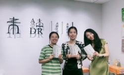 Lizzy, Susie and Yajie (v.r.n.l. Cheflektorin, Abteilungsleiterin Lizenzen, Lektorin) mit der chinesischen Ausgabe von "Schrecklich schön und weit und wild" vor dem neuen Verlagslogo von Weidu / UNREAD